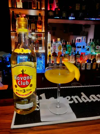 A bottle of Havana Club next to a cocktail on the bar
